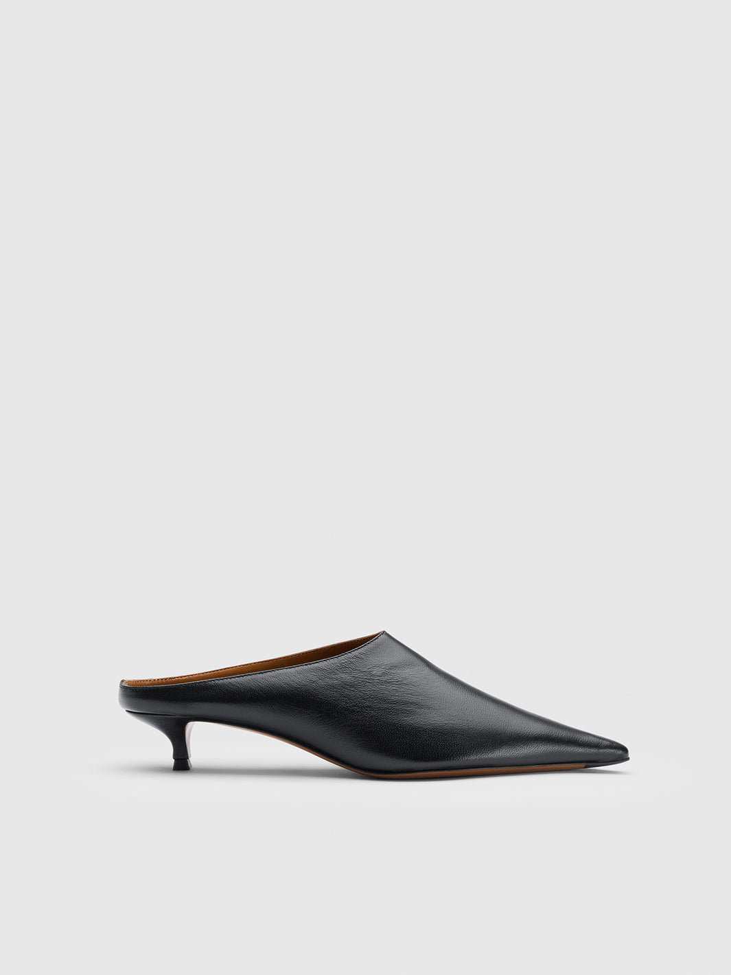 A single black leather pointed-toe mule heel shoe shown in profile against a light gray studio background.